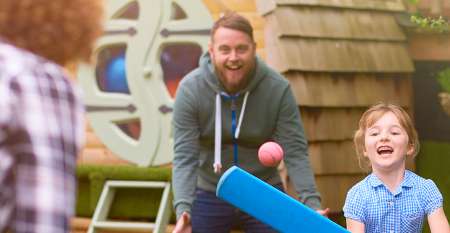 Family playing cricket in the garden