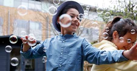 Two children playing with bubbles