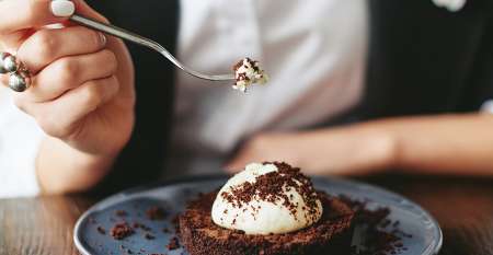 Woman eating chocolate dessert with cream