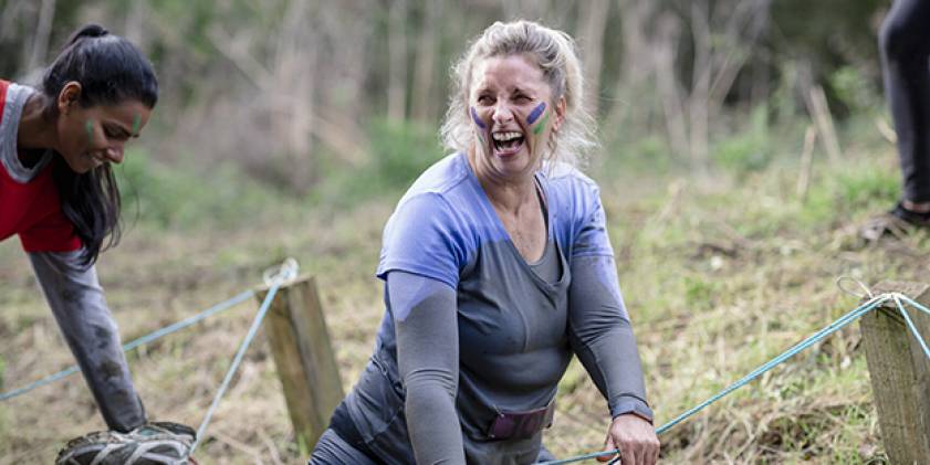 Woman enjoying muddy activity.